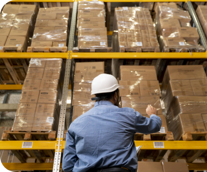 Warehouse employee counting loaded pallets on shelf